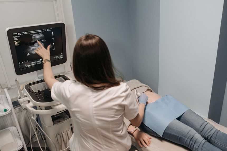 Profissional de saúde realiza exame de ultrassom em uma paciente em consultório médico.