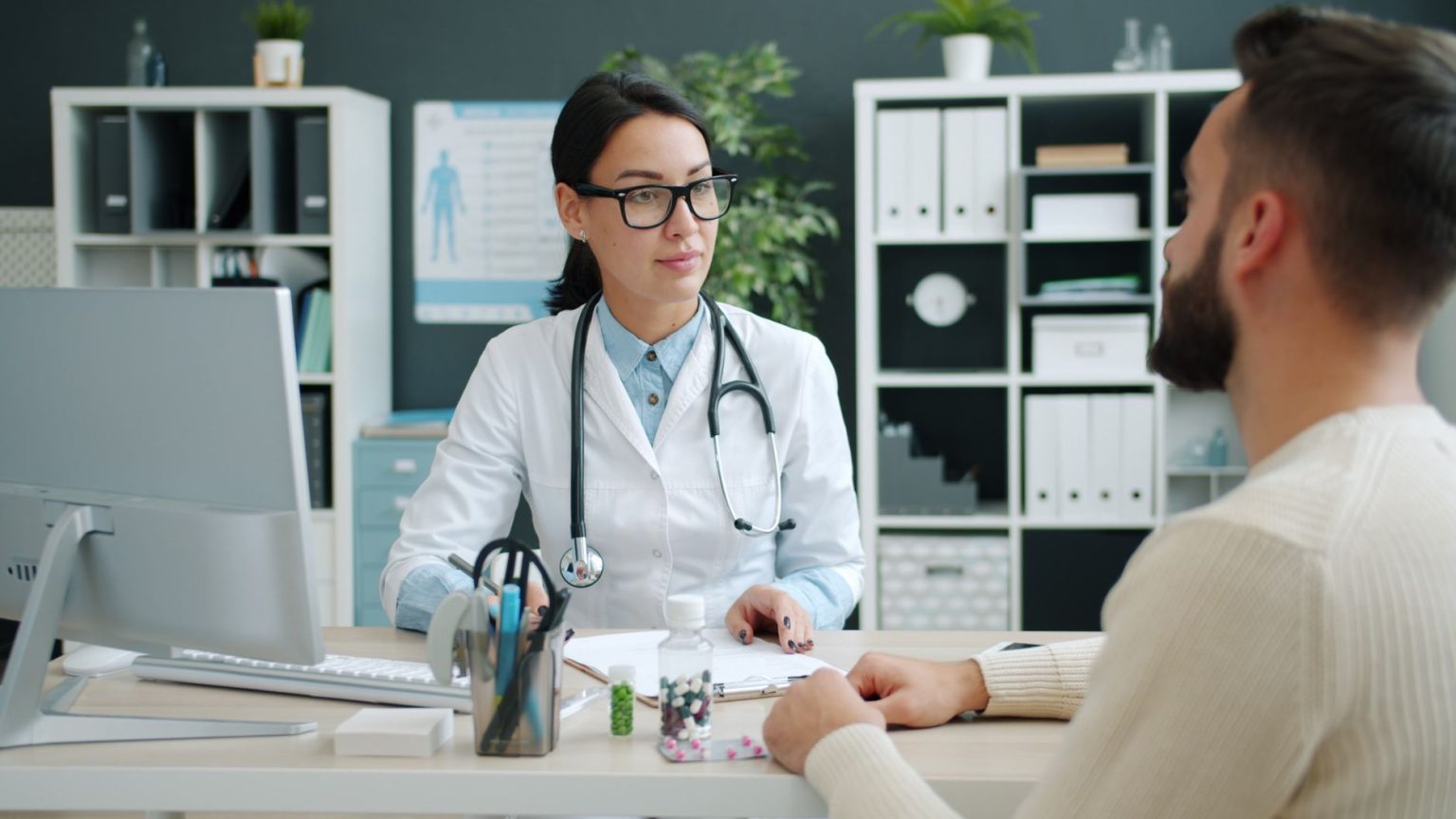 Médico conversa com uma paciente em uma clínica, discutindo opções de tratamento.